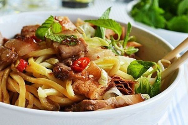 A close-up of a traditional Vietnamese dish like cao lau or banh mi on a colorful plate