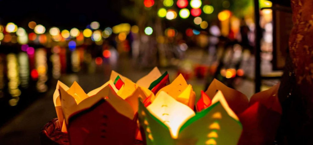 Close-up-of-tourist-releasing-lantern-on-Hoai-River