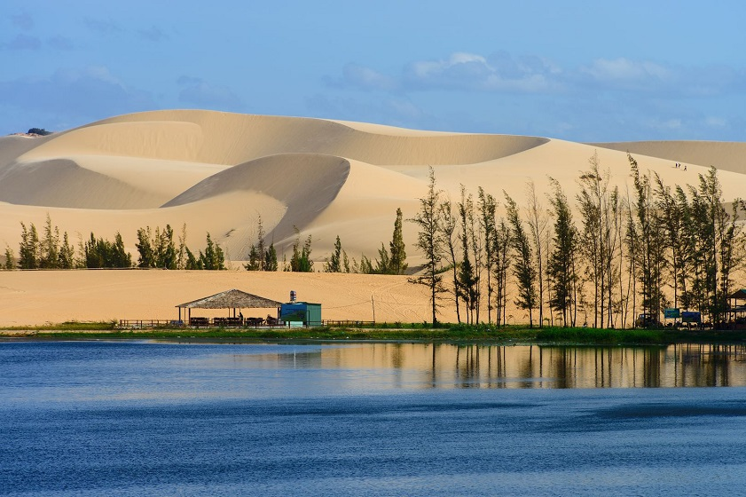 Wide panoramic view of white sand dunes and lake