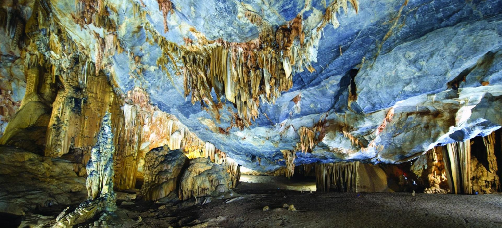 Entrance of Paradise Cave surrounded by lush forest